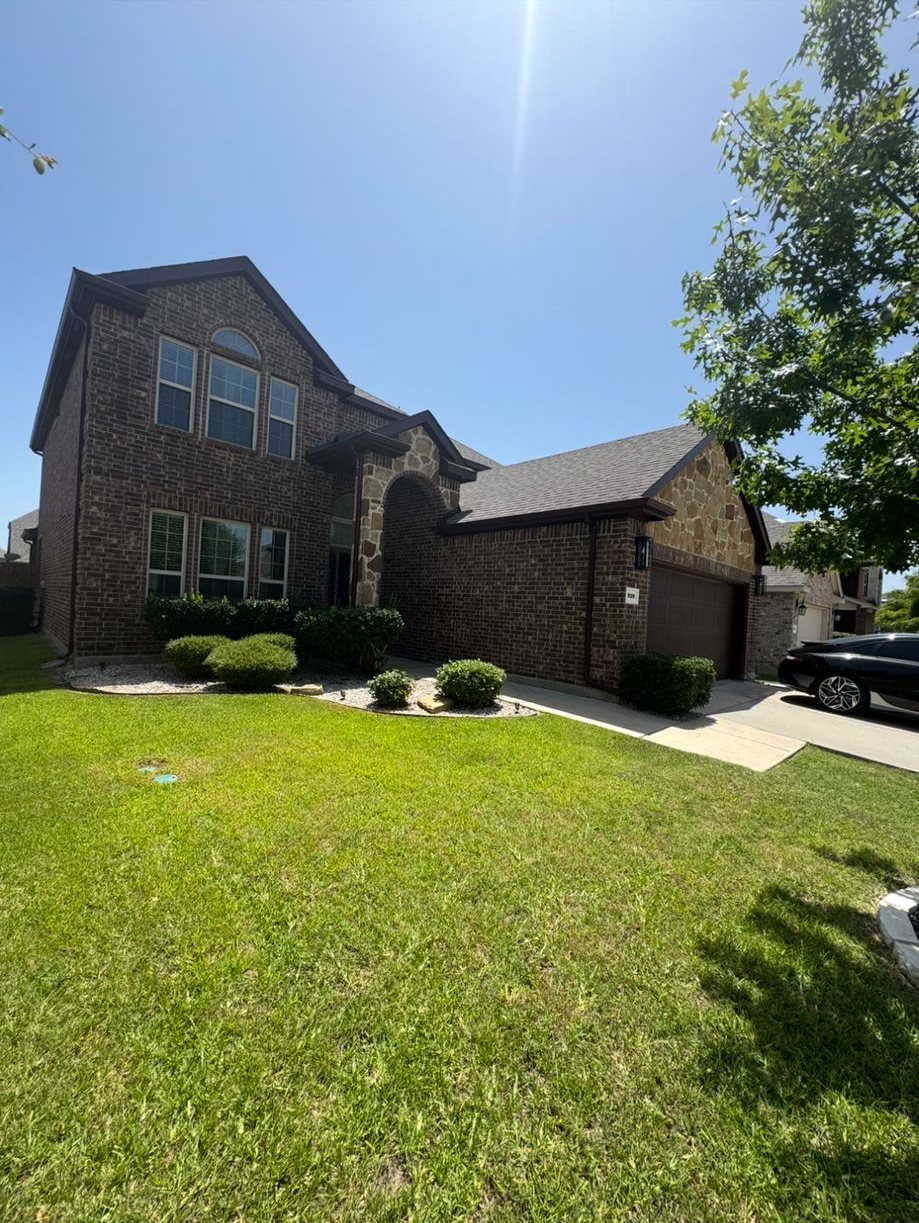 Exterior repaint on a two-story brick and stone home